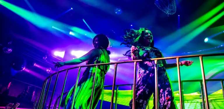 Concertgoers under colorful stage lights in Puerto Vallarta, used for Vibra Jalisco Fan Zone concert news