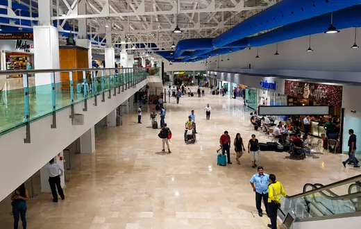 View from the second-floor escalator area toward the upper departure corridor at Puerto Vallarta airport